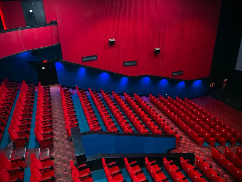 Auditorium rows of red seats with blue lighting